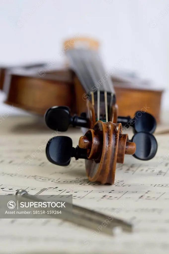 Antique violin and tuning fork lying on musical notes
