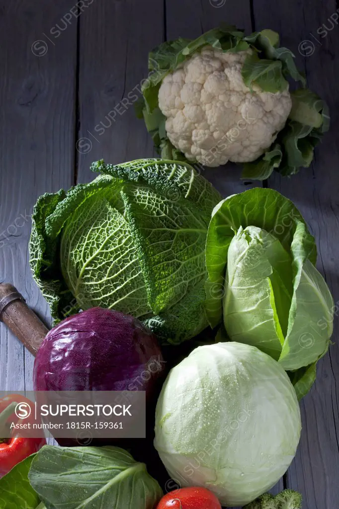 Cabbage varieties and antique knife on grey wooden table