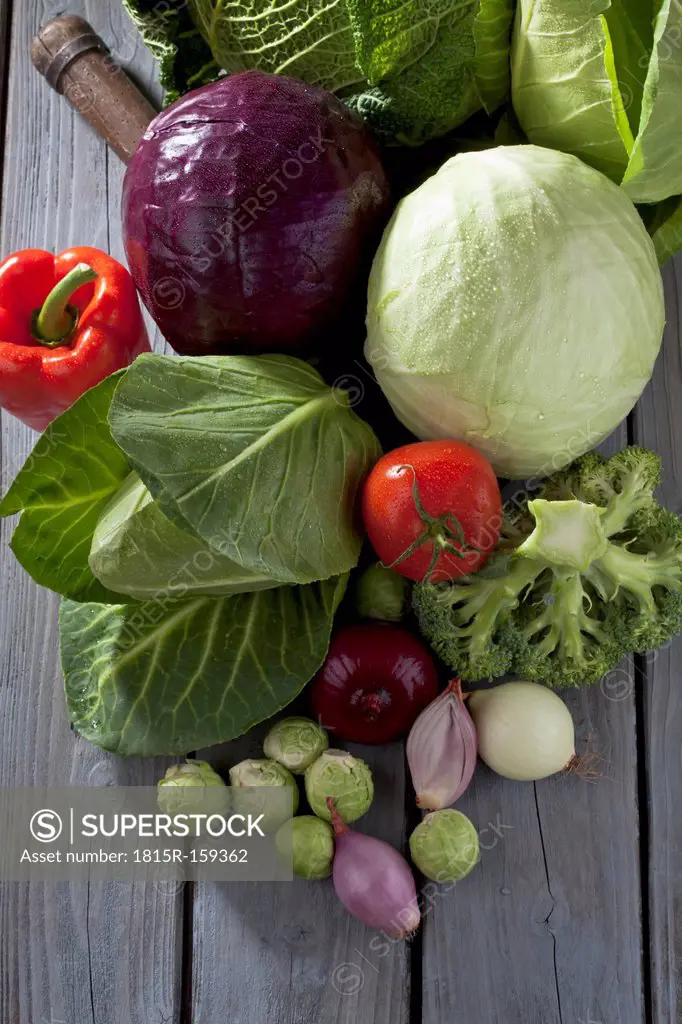 Cabbage varieties and other vegetables on grey wooden table