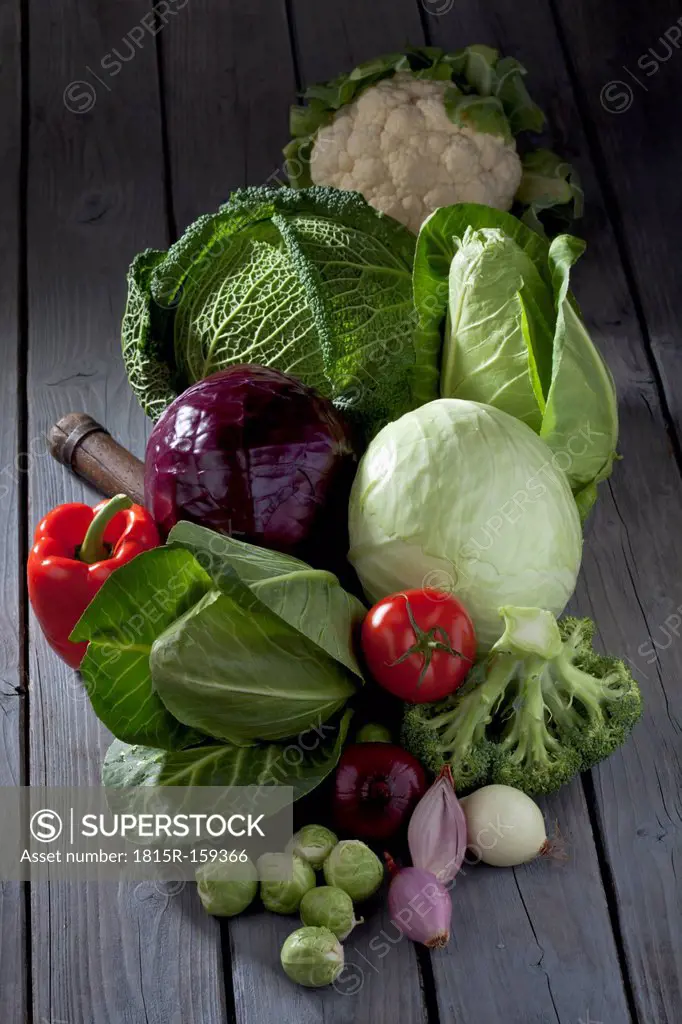 Cabbage varieties and other vegetables on grey wooden table
