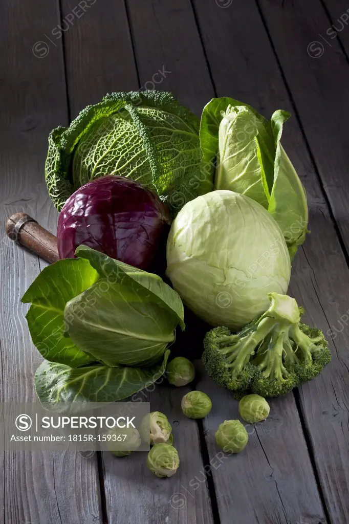 Cabbage varieties and antique knife on grey wooden table