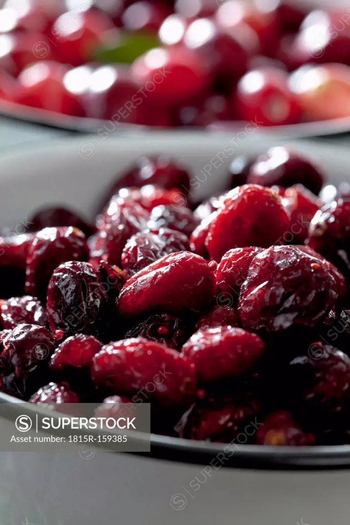 Two bowls of dried and fresh cranberries (Vaccinium macrocarpon), close-up