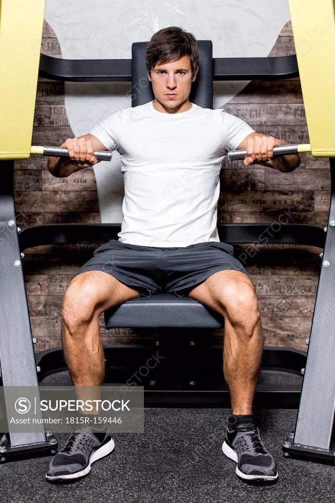 Austria, Klagenfurt, Man in fitness center doing machine workout