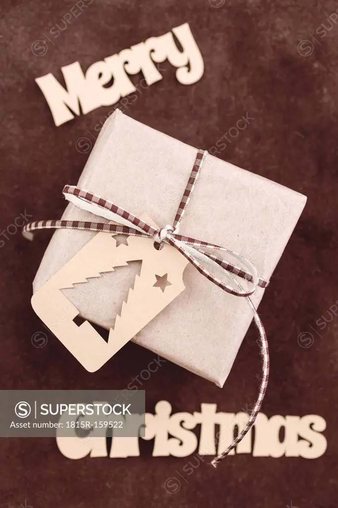 Christmas gift with gift tag on rustic leather