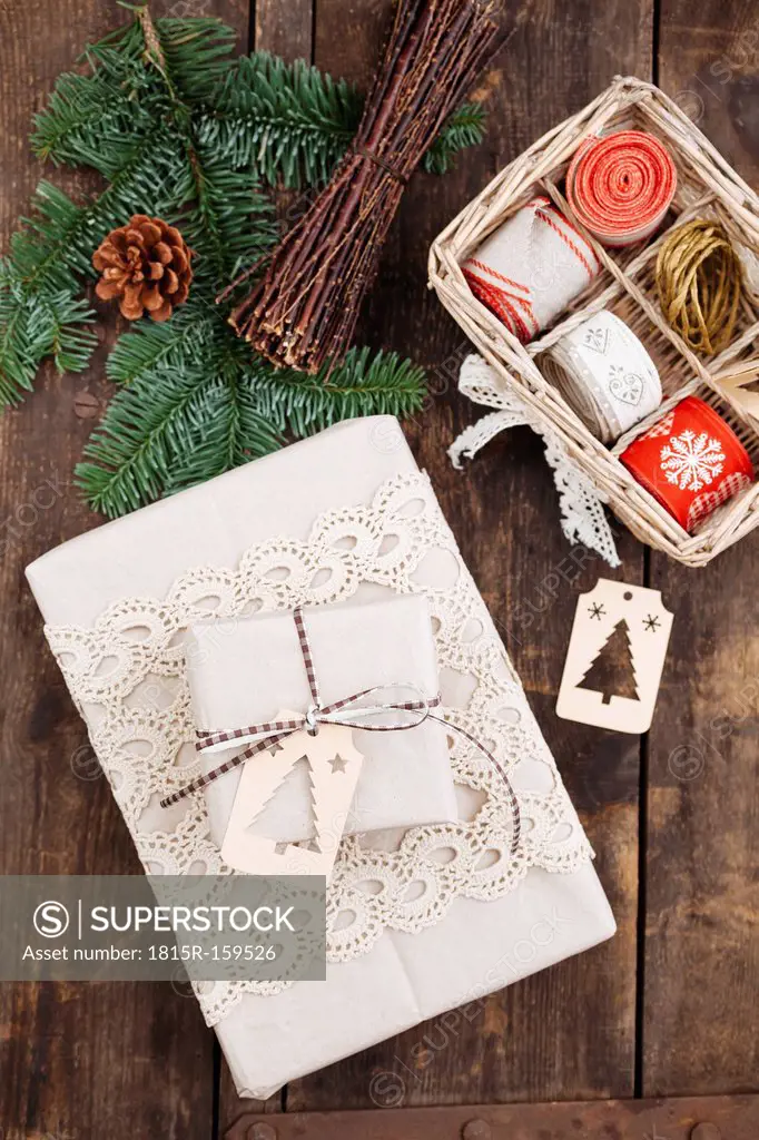 Christmas gift with gift tag and wrapping material on wooden table