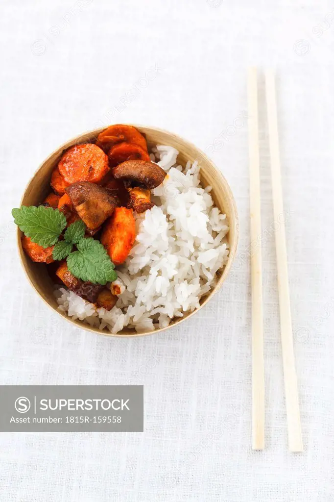 Bowl of Thai jasmine rice with coconut milk and fried carrots and crimini mushrooms