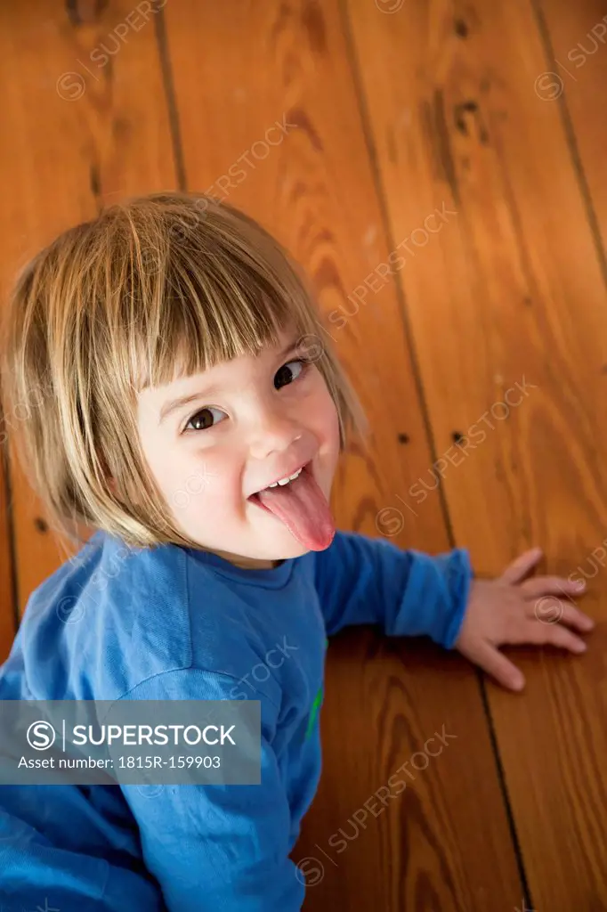 Portrait of little girl with outstretched tongue
