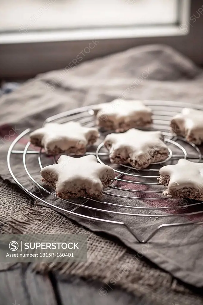 With powdered sugar sprinkled star-shaped cinnamon cookies on cooling grid