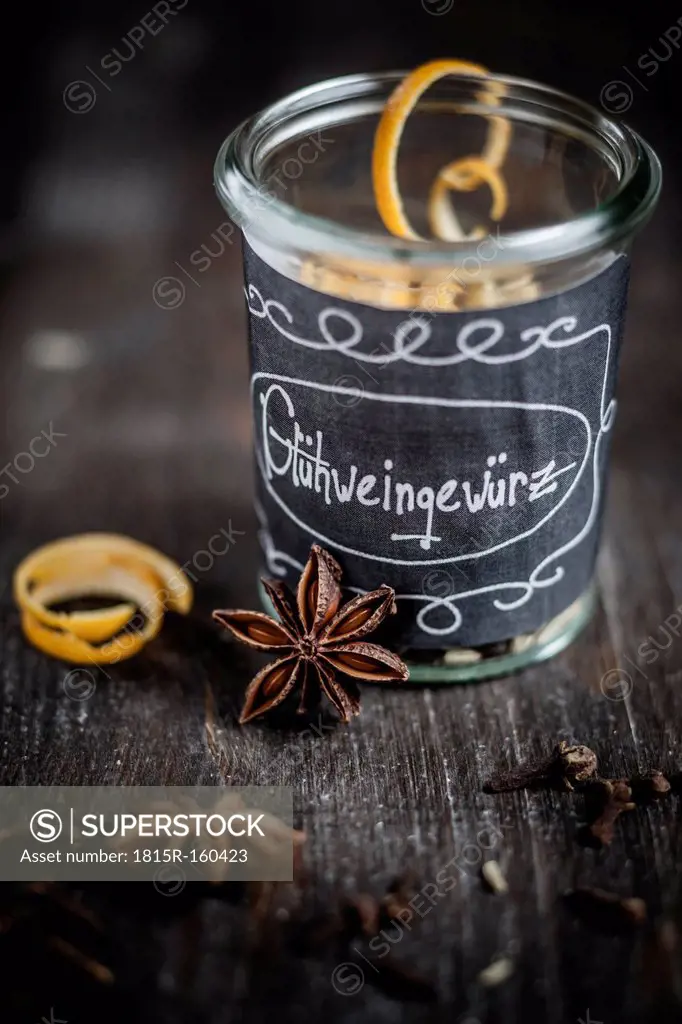 Preserving jar with spices for mulled wine on wooden table