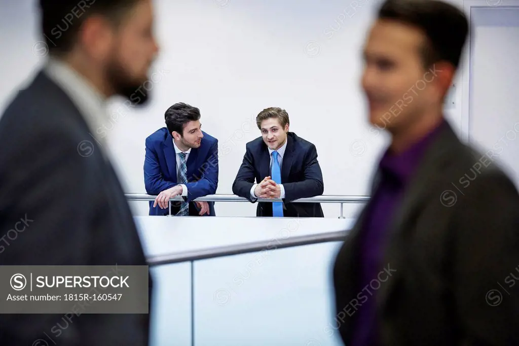 Germany, Neuss, Businessmen talking in corridor