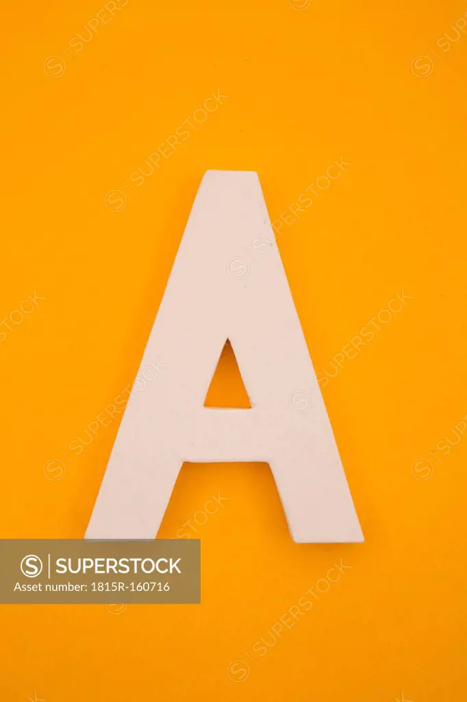 White letter A formed at yellow background, studio shot