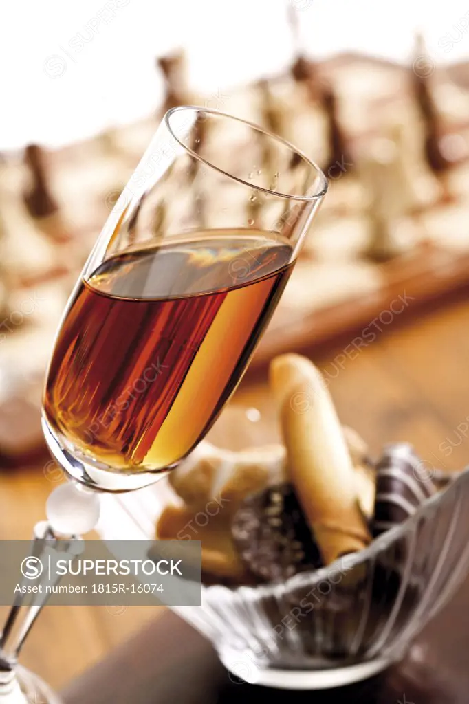 A glass of sherry beside a bowl with cookies