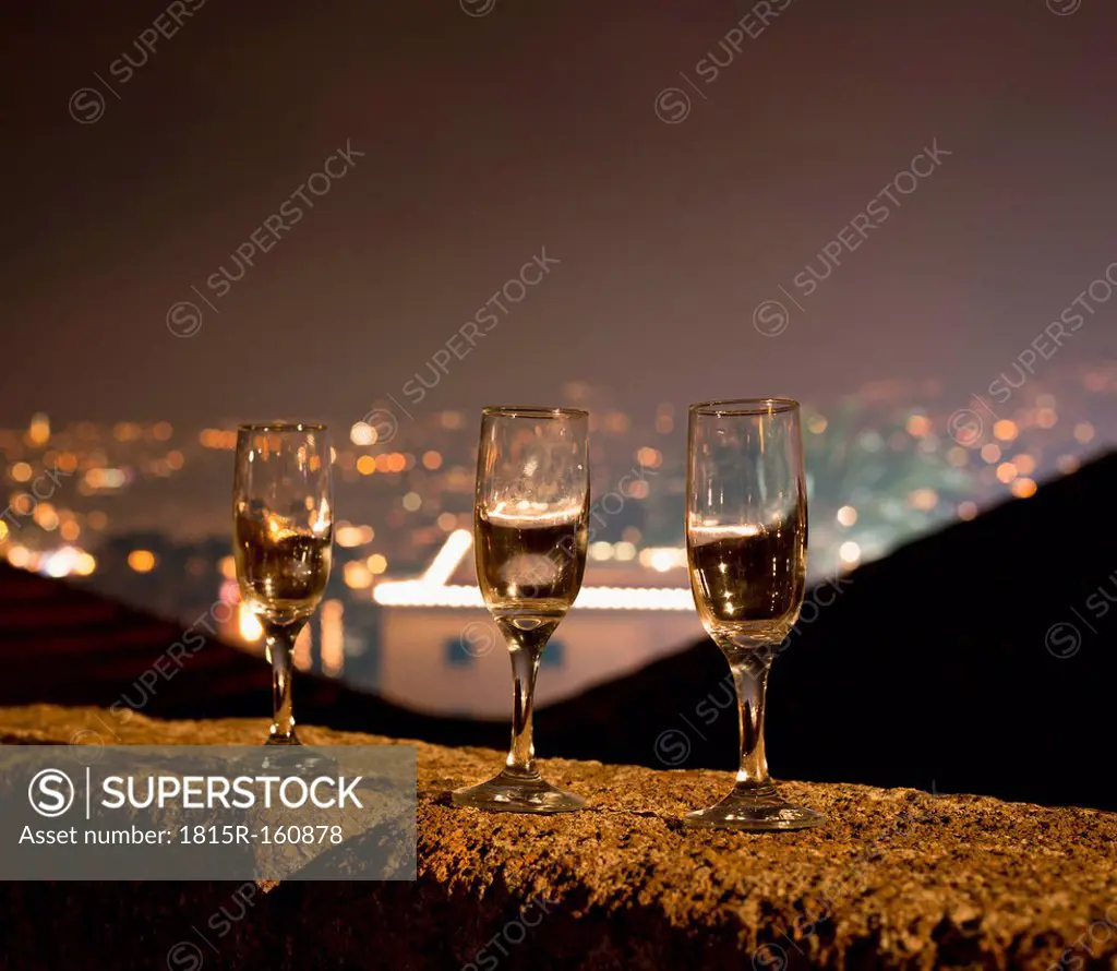 Portugal, Madeira, Funchal, Forte de Sao Tiago, three empty champagne glasses standing on balustrade at New Year's Eve