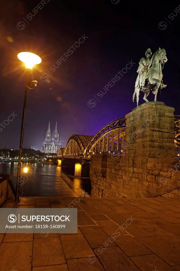 Germany, North Rhine-Westphalia, Cologne, lighted Cologne Cathedral and Hohenzollern Bridge with monument of Wilhelm I at night