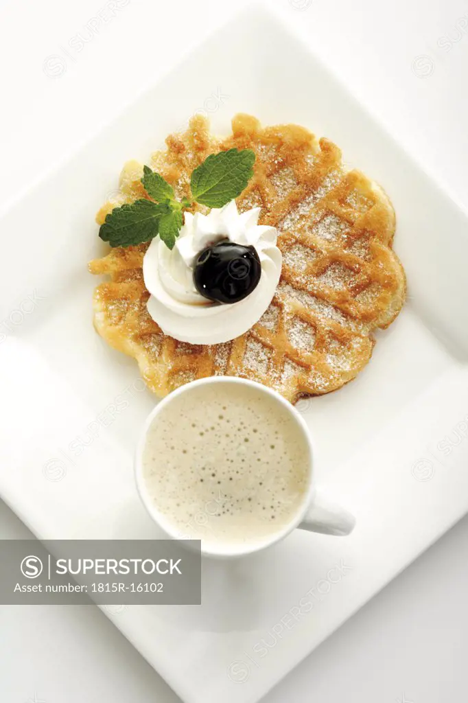 Waffle with whipped cream and a cup of coffee, elevated view