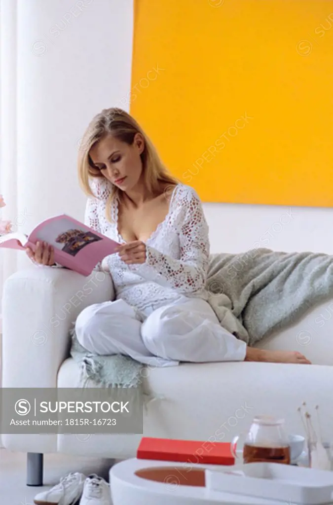 Woman on sofa reading book