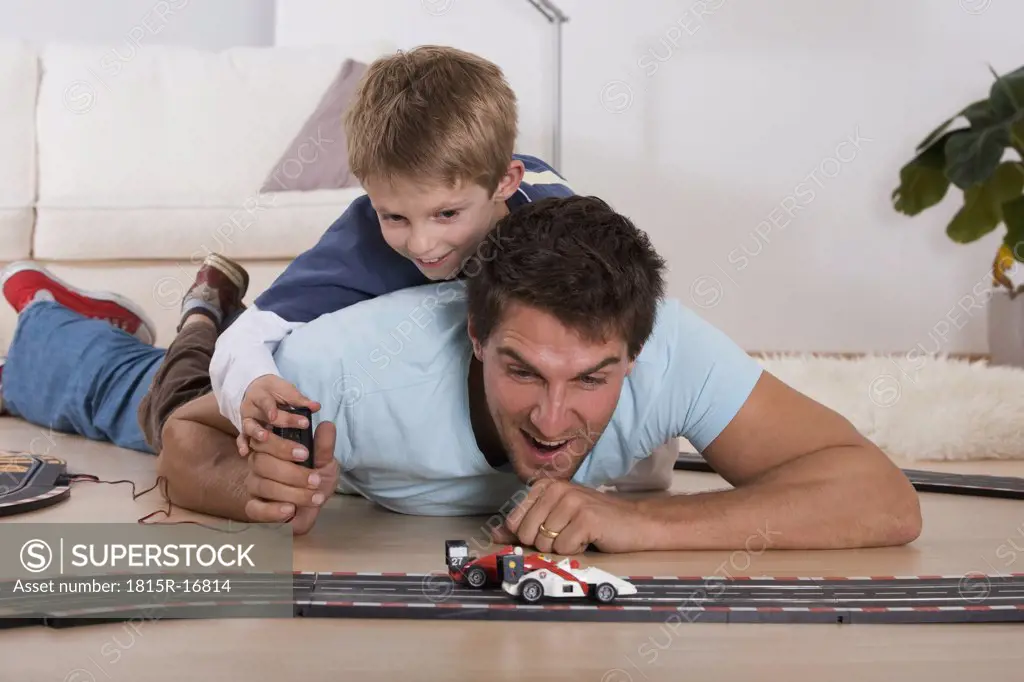 Father and son (8-9) playing with toy cars