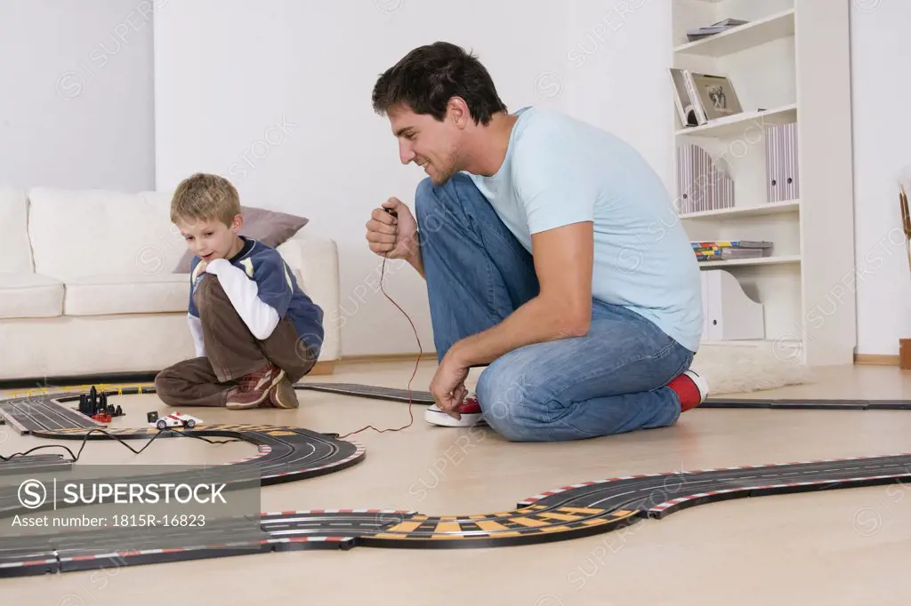 Father and son playing with toy racetrack
