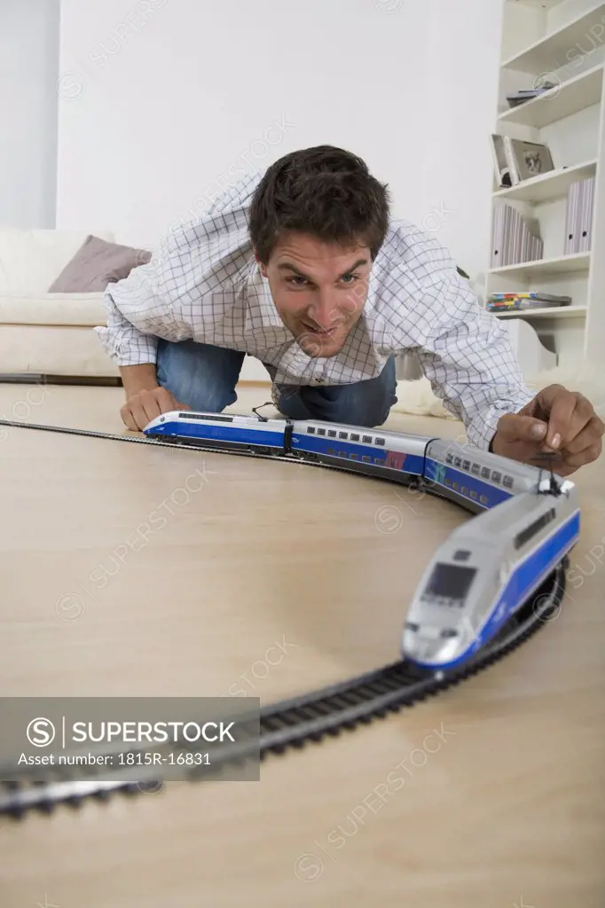 Man playing with toy train, close-up