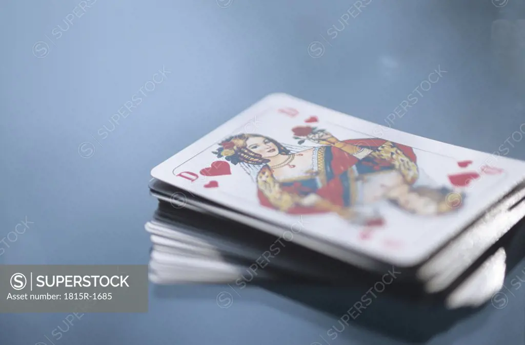 Pack of cards on a table, queen of hearts