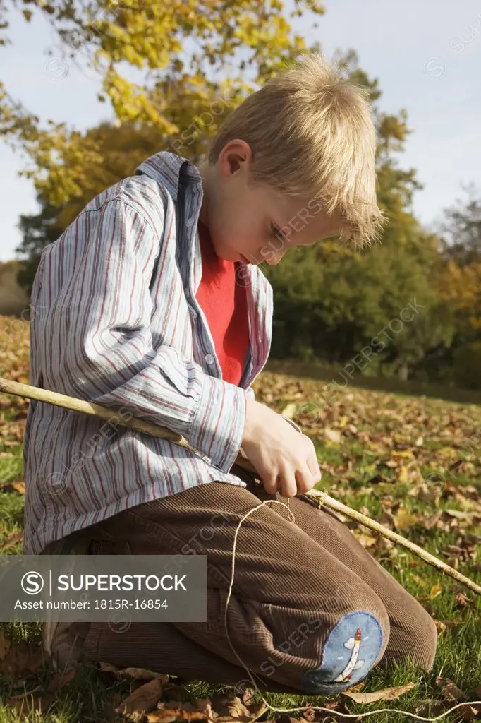 Boy (10-12) crafting fishing pole