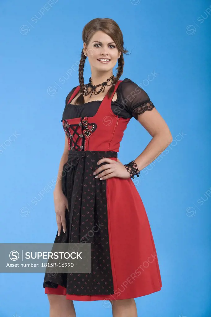 Young woman in traditional costume, hand on hip, smiling, portrait