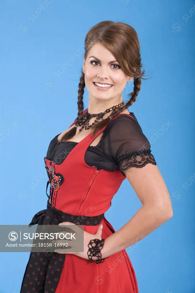 Young woman in traditional costume, hands, hand on hip, smiling, portrait
