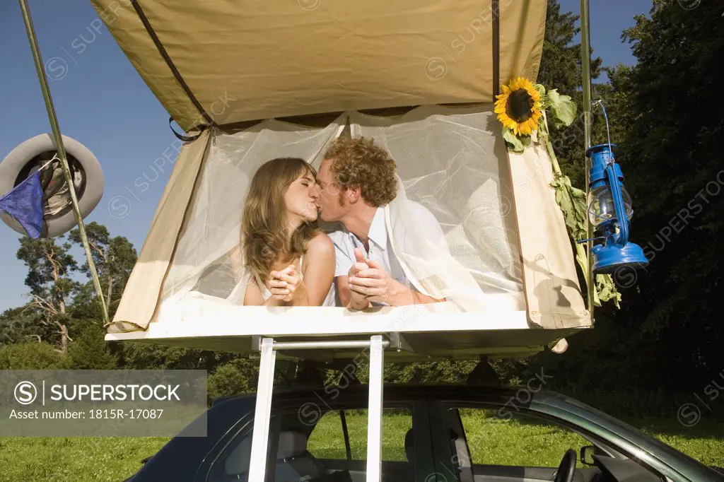 Germany, Bavaria, Young couple laying in tent