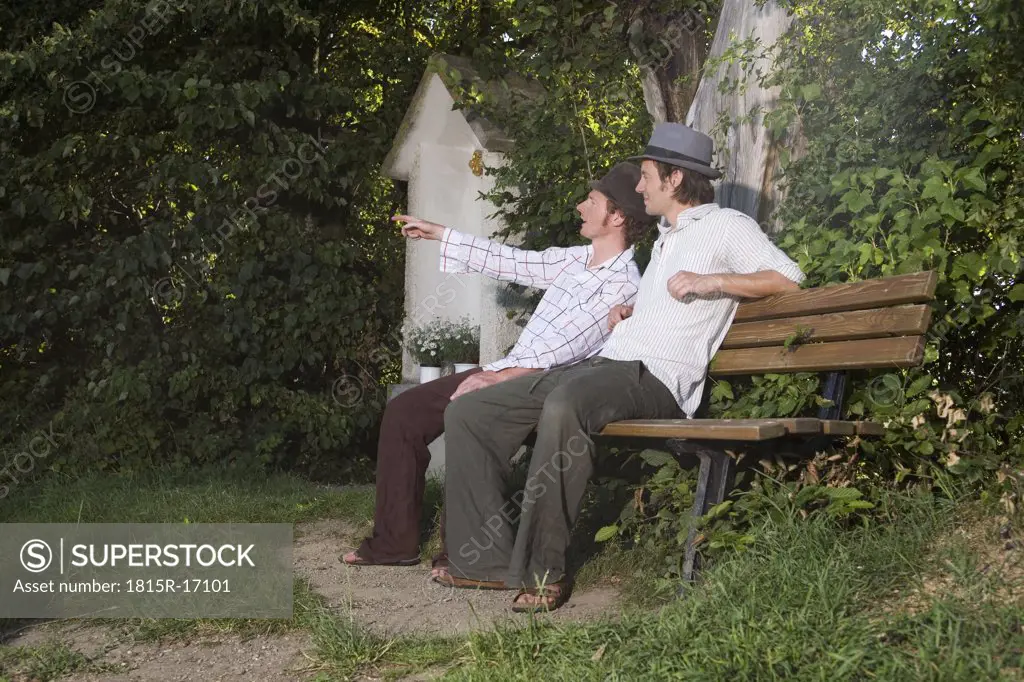 Germany, Bavaria, Young men sitting on bench