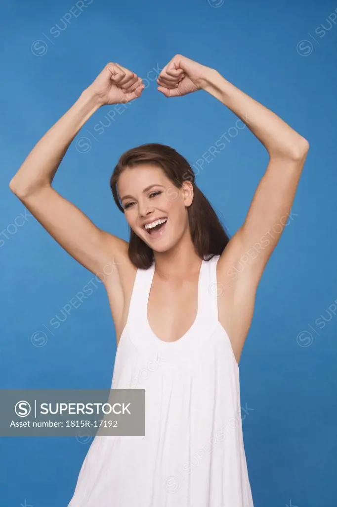 Young woman clenching fists, cheering, portrait