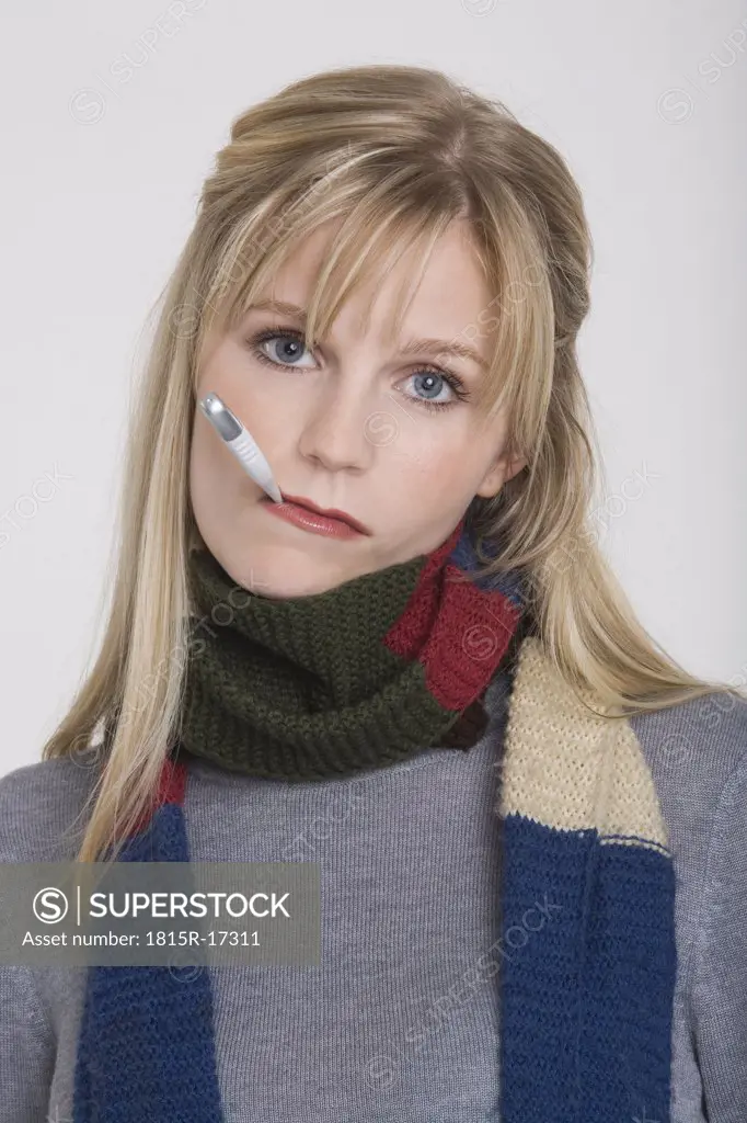 Young woman holding a clinical thermometer