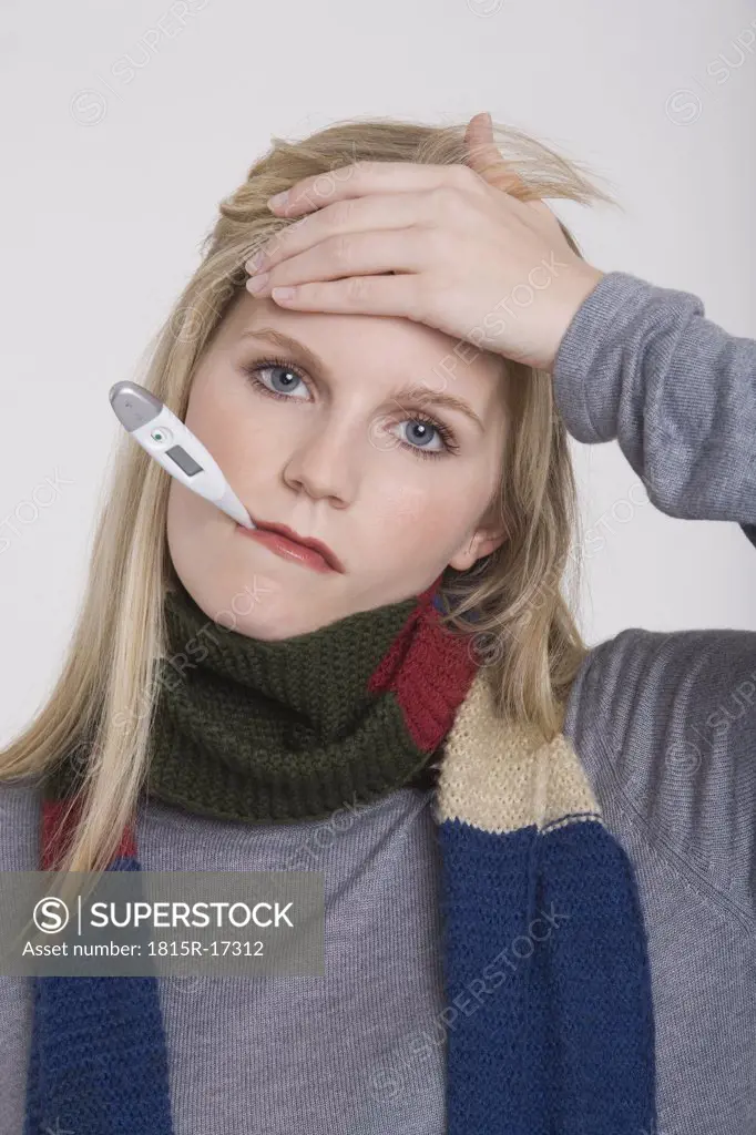 Young woman holding a clinical thermometer