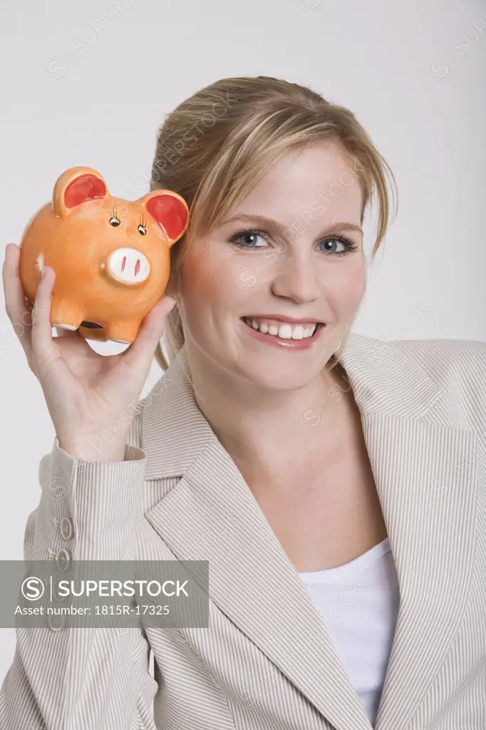 Young woman holding a piggybank, portrait