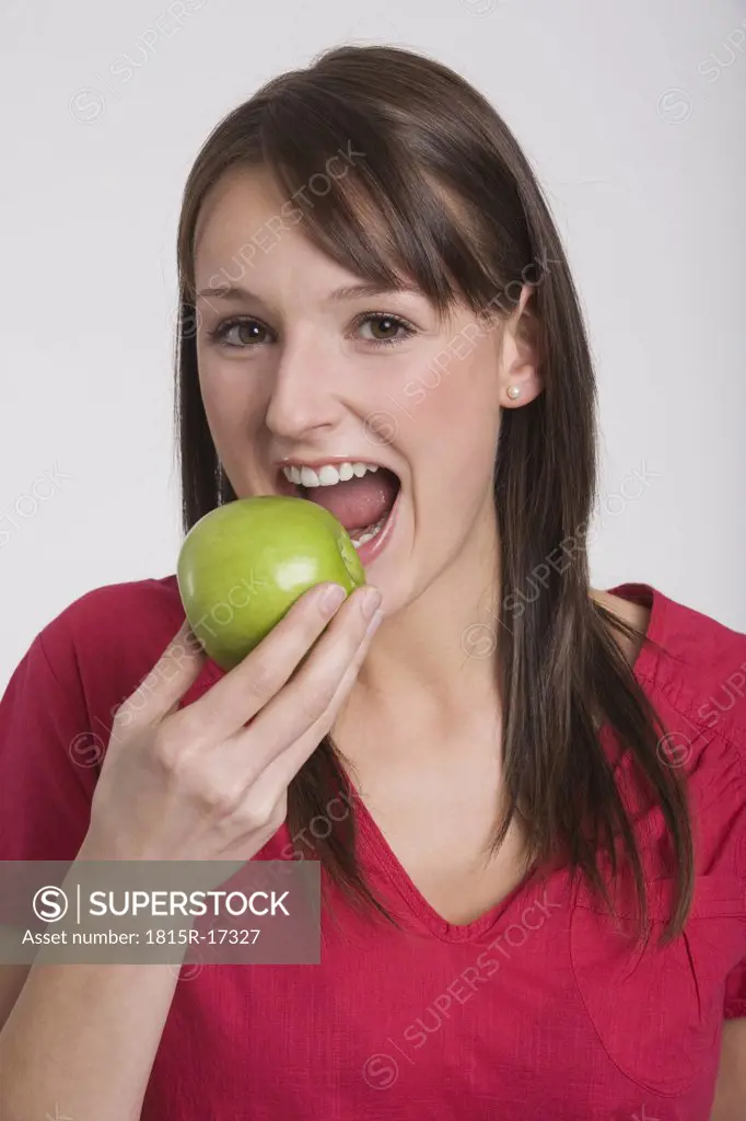 Young woman holding an apple, portrait