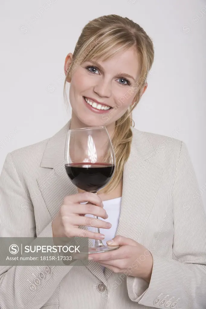 Young woman holding a glass of red wine, portrait