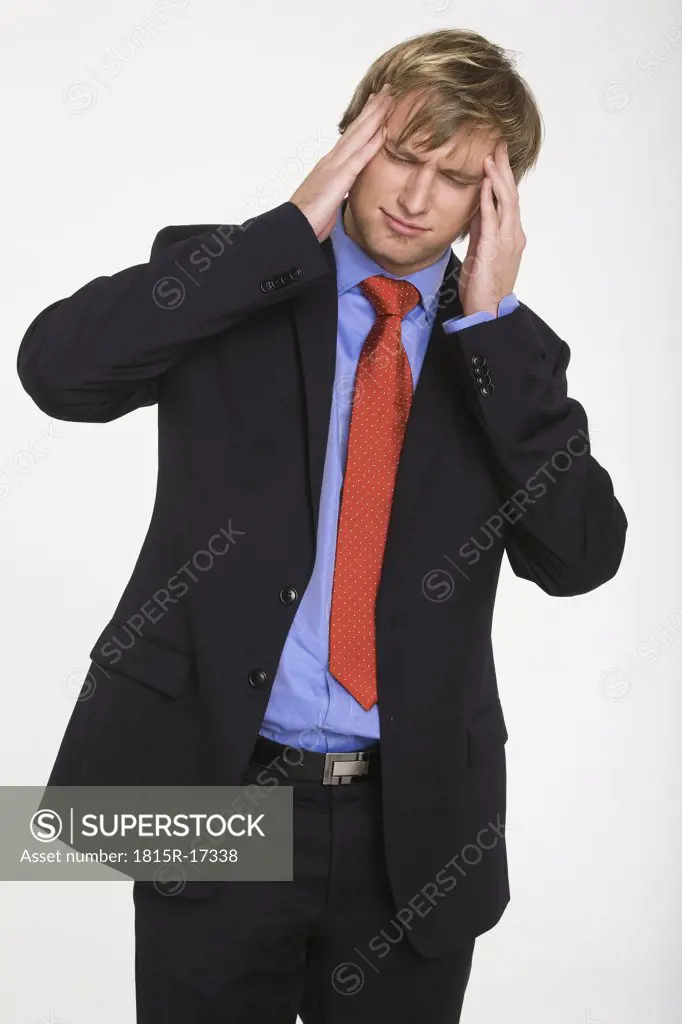 Young businessman, hands to head, portrait