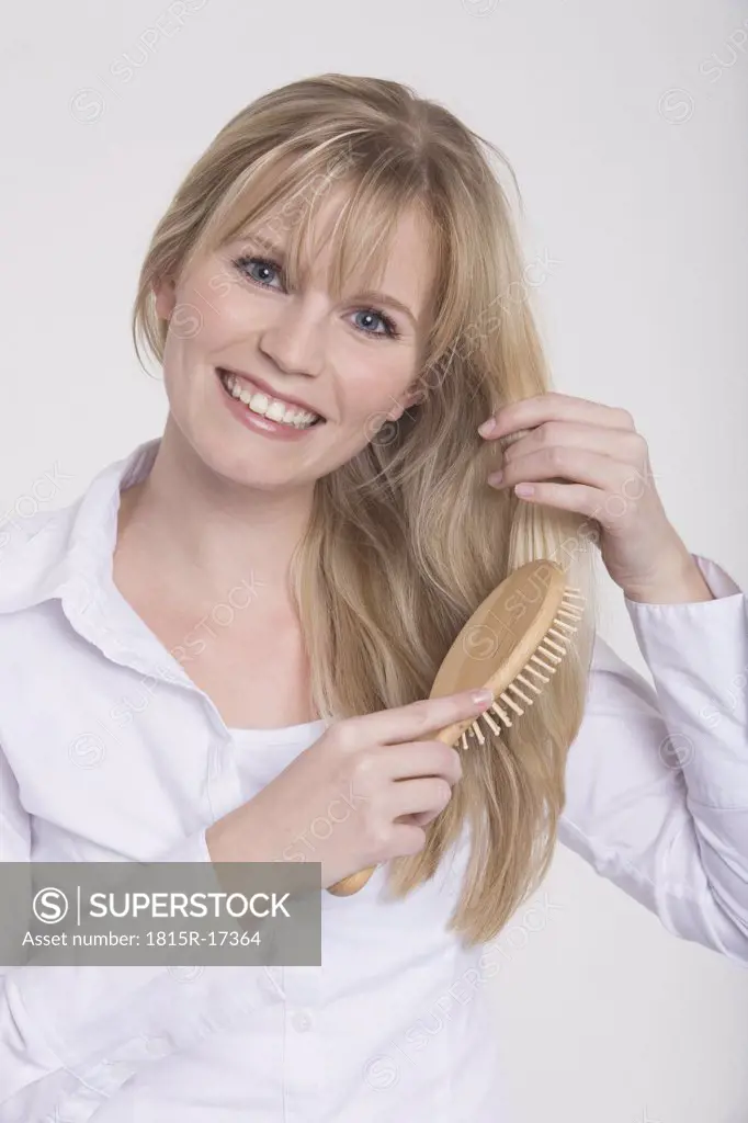 Young woman combing her hair, portrait