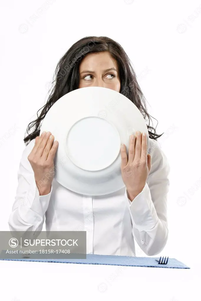 Woman holding plate, partly obscuring face, portrait