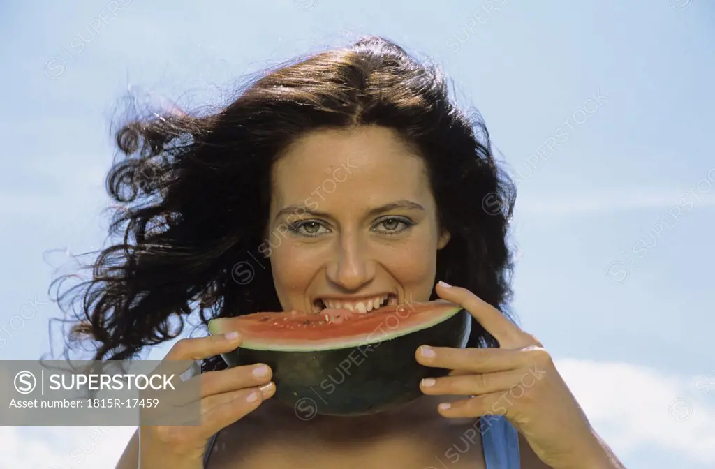 Young woman eating watermelon, portrait