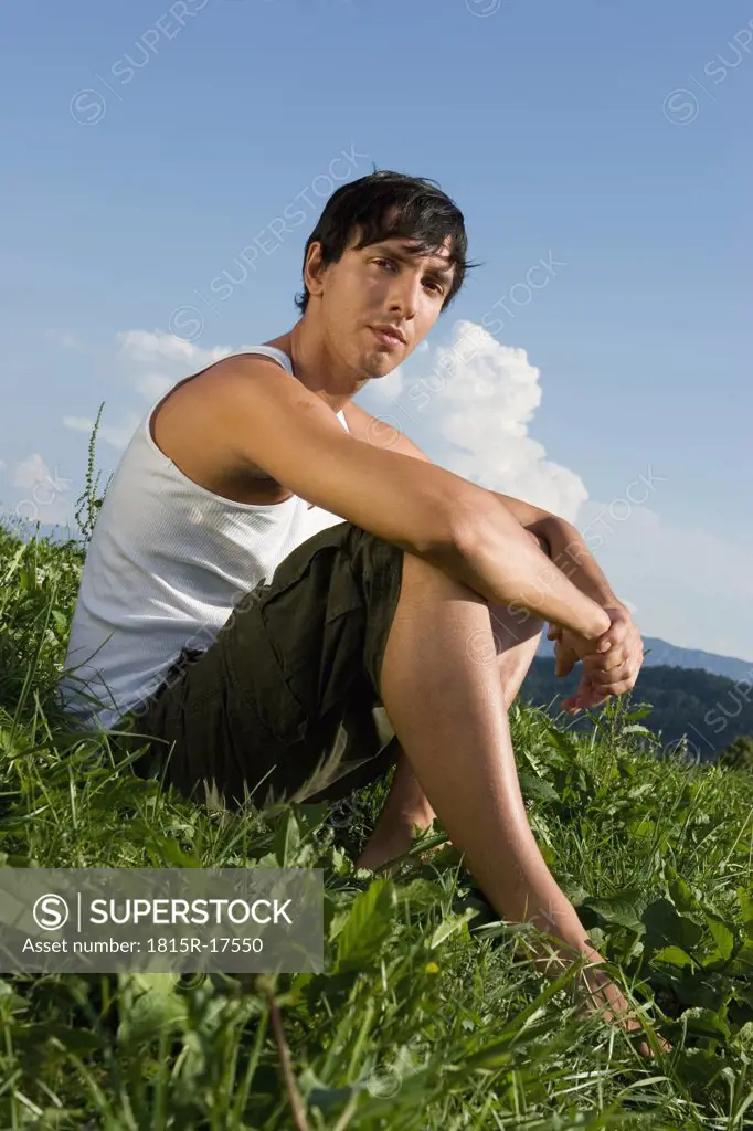 Young man sitting in meadow