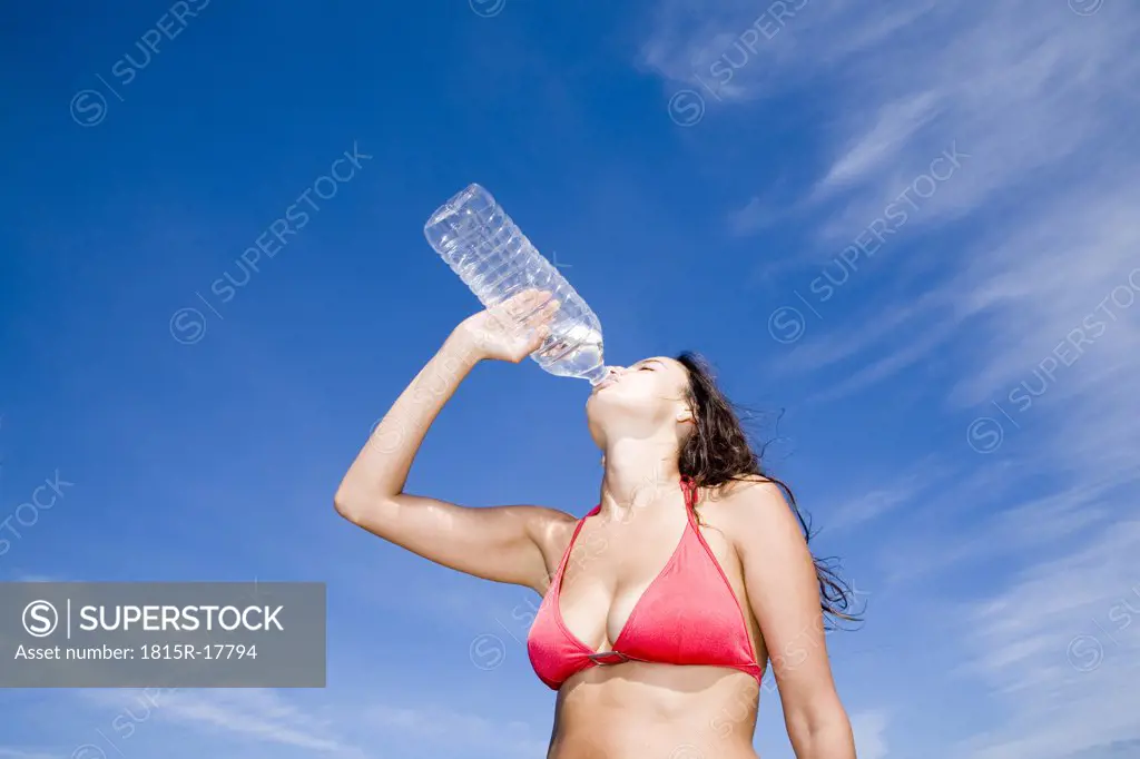 Young woman drinking from water bottle