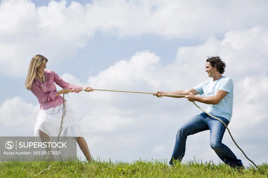 Couple pulling rope, close-up