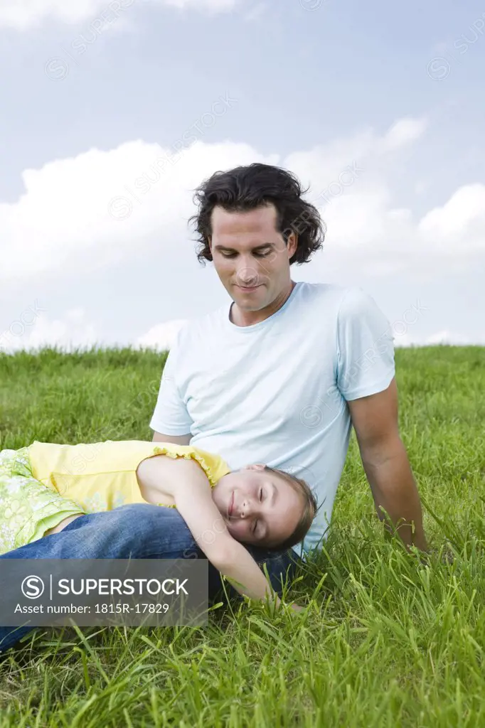 Girl sleeping on fathers lap