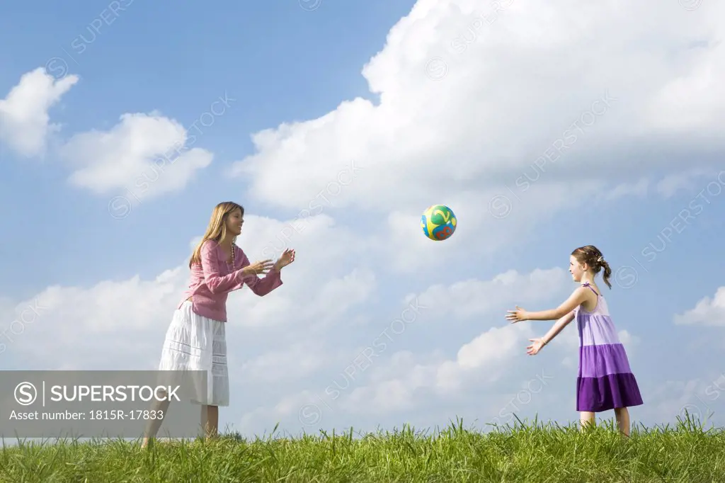 Mother and daughter playing with ball