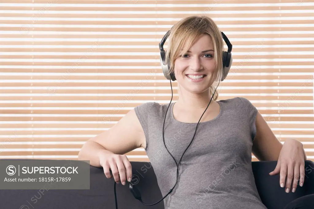 Blonde woman relaxing, smiling, with headphones, portrait