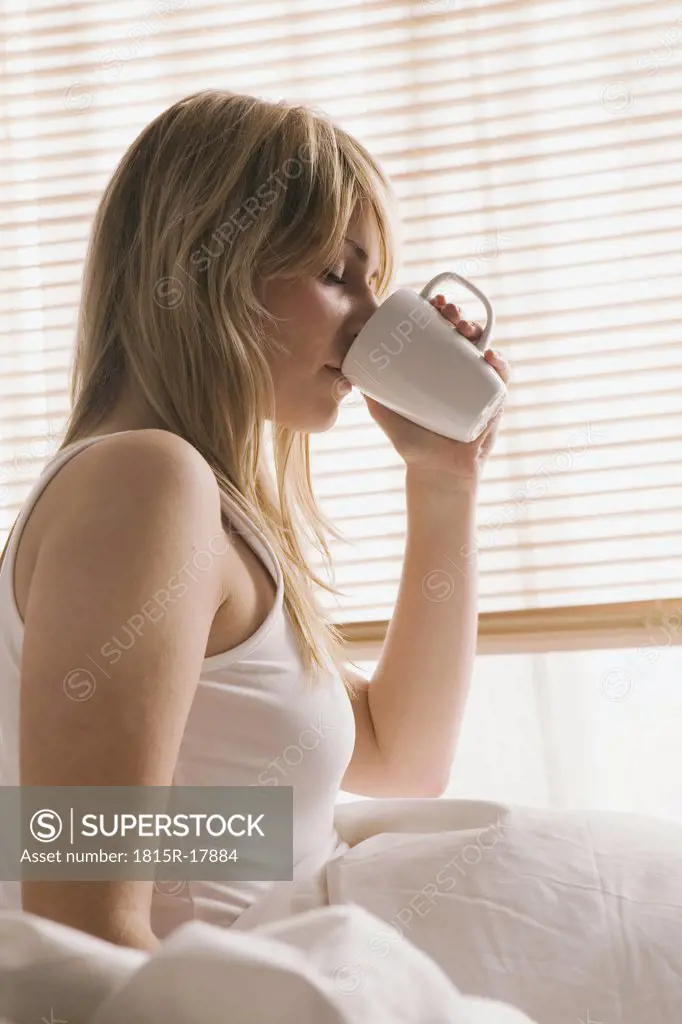 Blonde woman drinking a cup of coffee, portrait