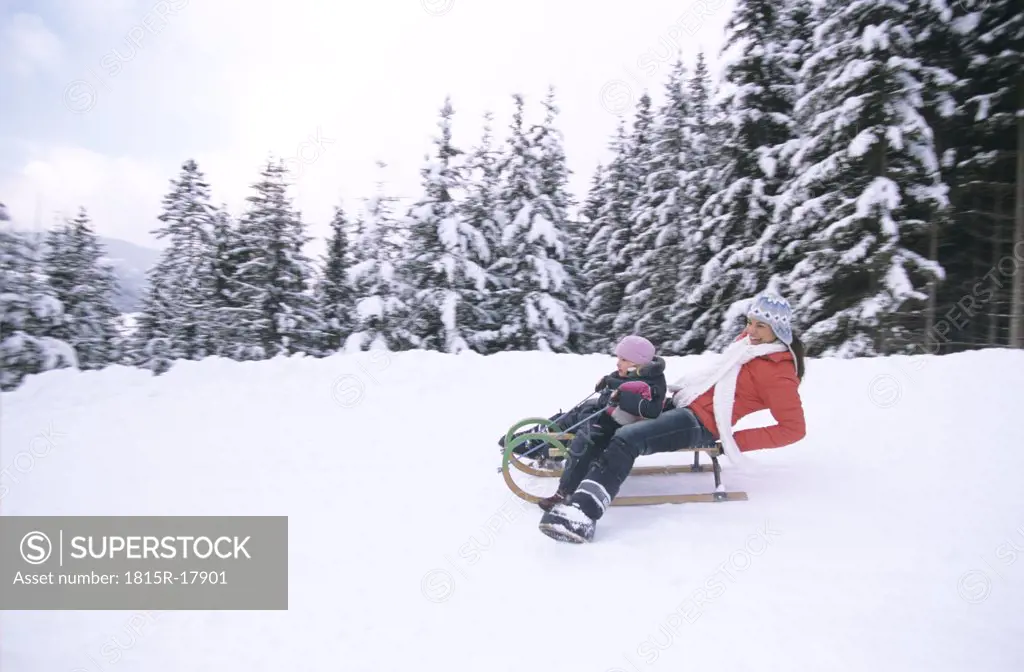 Woman and child riding on sledge