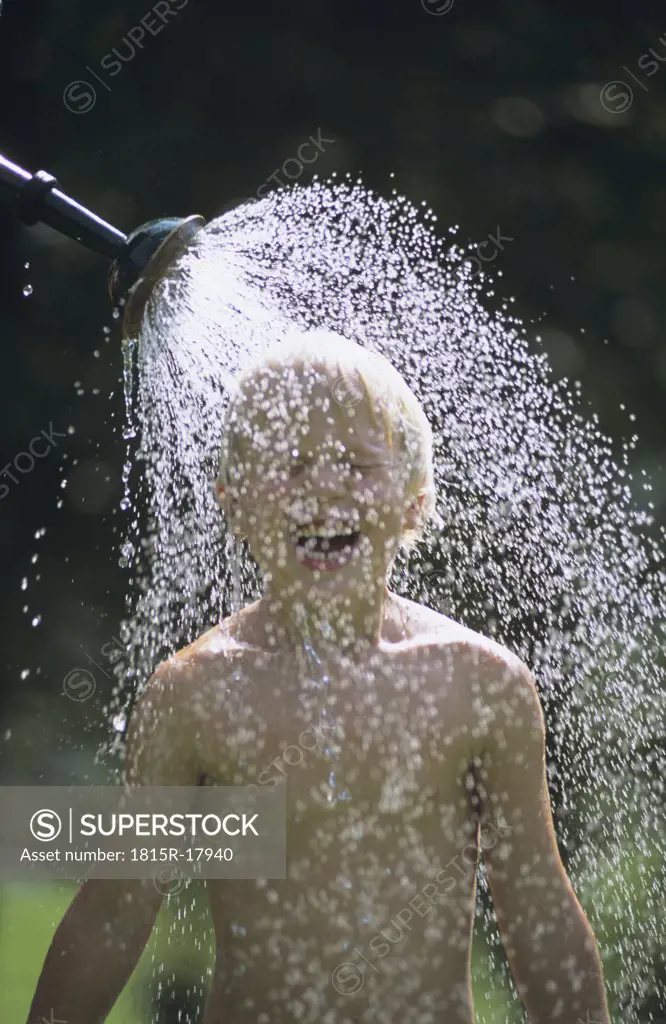 Boy having a shower in the garden