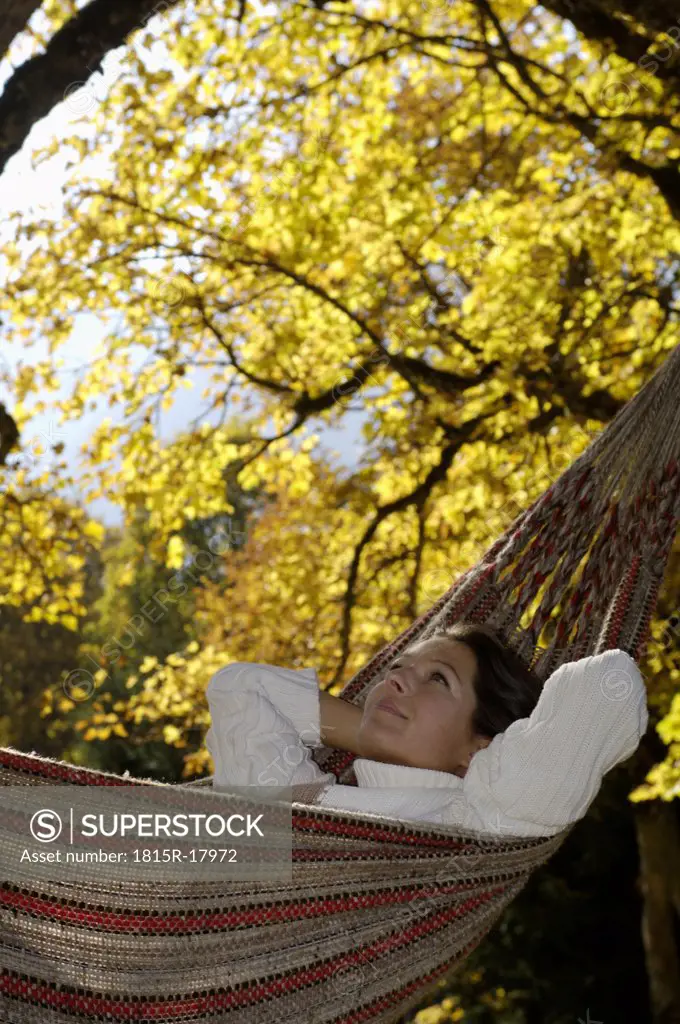 Woman lying in hammock, looking up