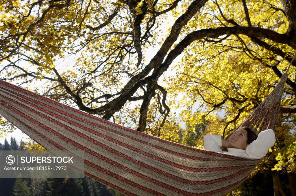 Woman lying in hammock looking up